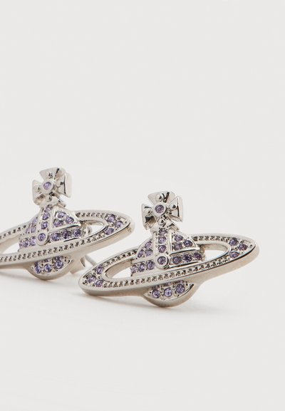 Ασημένια σκουλαρίκια σε σχήμα Κρόνου με μοβ πολύτιμους λίθους, που διαθέτουν περίτεχνη λεπτομέρεια και υφασμένο δαχτυλίδι γύρω από τον πλανήτη.