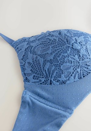 Blå blondebh med blomstermønstre og en struktureret underkant. Glat stof, justerbare stropper og et blødt, detaljeret design.