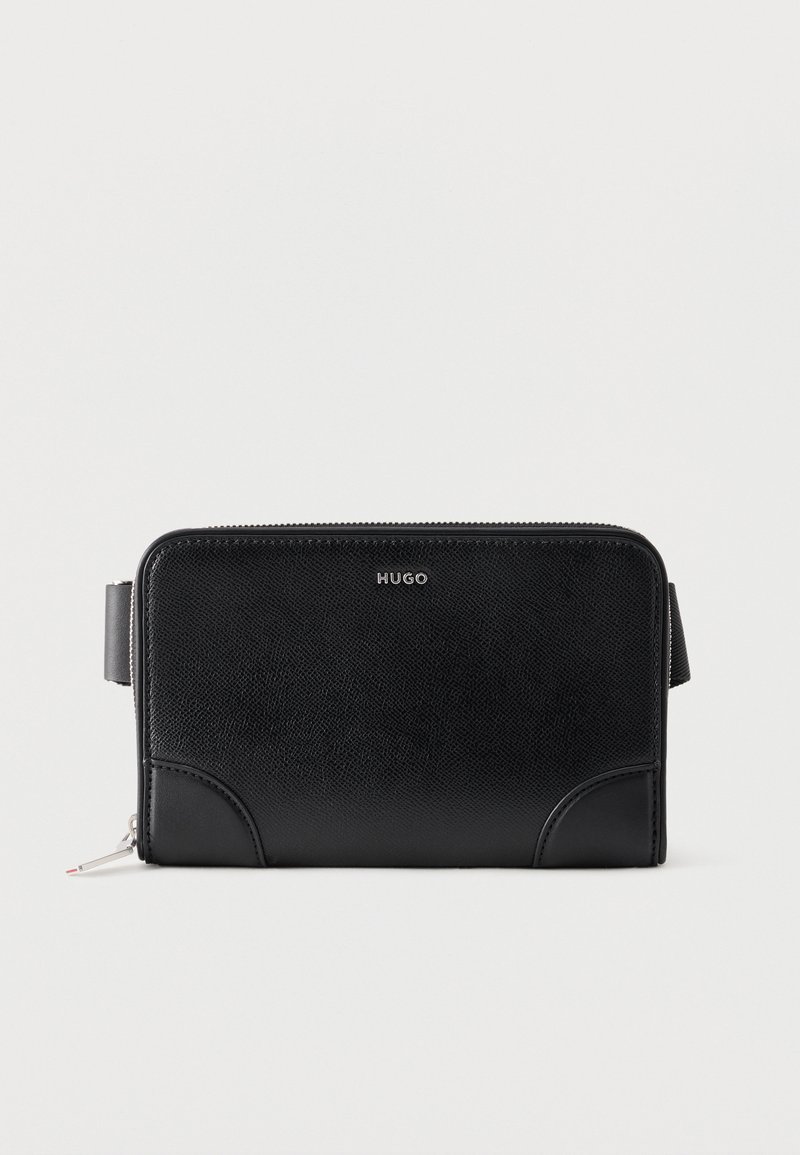 Μαύρο δερμάτινο πορτοφόλι Hugo με φερμουάρ, υφή, ραφές στις γωνίες και λουράκι στο πλάι, σε λευκό φόντο.
