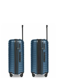 Valigia rigida di colore blu scuro, con superficie texturizzata, manico retrattile e quattro ruote per la mobilità. Chiusura con zip sul davanti.