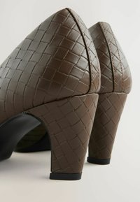 Brown, woven-pattern, high-heeled shoes with a pointed toe and textured finish; features a black interior and chunky heel design.