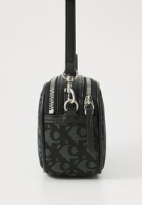 Borsa rotonda nera con pattern testurizzato, doppie cerniere e tracolla in pelle. Presenta dettagli e accessori in tonalità argento.