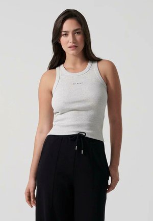 Débardeur gris à côtes avec un col rond et un logo sur le devant, associé à un pantalon noir avec cordon de serrage. Texture lisse, design ajusté.
