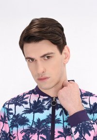 Jachetă cu mâneci scurte, cu fermoar, având un model cu palmieri roz și albastru, realizată dintr-un material neted, cu guler și manșete închise la culoare.