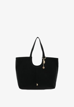 Sac cabas noir avec doubles poignées, breloque dorée et petit emblème décoratif sur le devant, sur fond blanc.
