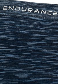 Marinblå sporttyg har en texturerad design med olika nyanser av blått och grått. Midjebandet visar "ENDURANCE" i ljusgrå bokstäver.