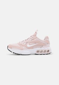 Scarpa sportiva rosa chiaro realizzata in mesh e materiali sintetici. Presenta accenti bianchi, una suola imbottita e un sistema di allacciatura prominente.