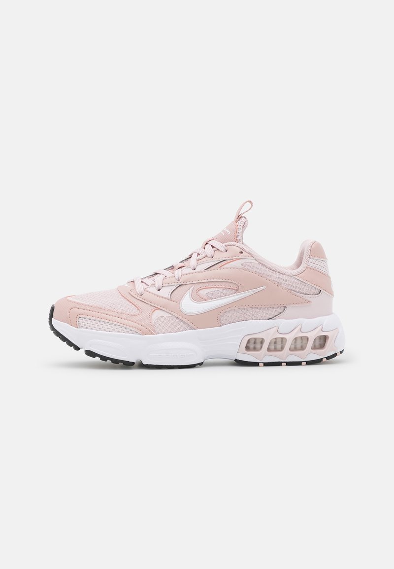 Scarpa sportiva rosa chiaro realizzata in mesh e materiali sintetici. Presenta accenti bianchi, una suola imbottita e un sistema di allacciatura prominente.