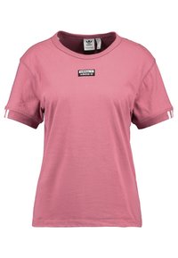 Růžové bavlněné tričko s kruhovým výstřihem, s černým logem Adidas, bílými pruhy na rukávech, krátkými rukávy a volným střihem.