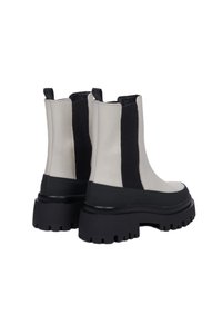 Masivní kotníkové boty s bílou koženou svrchní částí, černými elastickými bočními panely a silnou černou gumovou podešví s texturovaným vzorem.