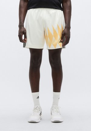Pantaloni scurți atletici pentru bărbați, de culoare crem, cu model de diamante galbene. Au talie elastică, material texturat și trei dungi negre pe lateral.