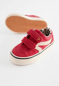 Baskets rouges en suede et toile avec doubles bandes Velcro, détails noirs et doublure en imprimé léopard. Semelle extérieure en caoutchouc texturé.