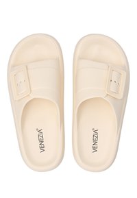 Lyse beige sandaler med en struktureret overflade, der har en bred rem og en firkantet spænde. Fremstillet af fleksibelt materiale, designet til komfort.