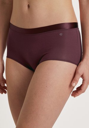 Shorts bordeaux en tissu doux et extensible avec une large ceinture brillante. Présente des coutures lisses et un petit logo sur le côté.