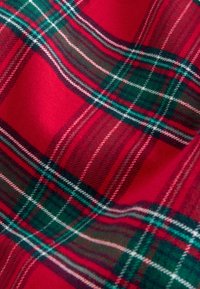 Roter Tartan-Stoff mit grünen und weißen Streifen, weich im Griff und im klassischen Karomuster, was ein warmes, lebhaftes Erscheinungsbild erzeugt.
