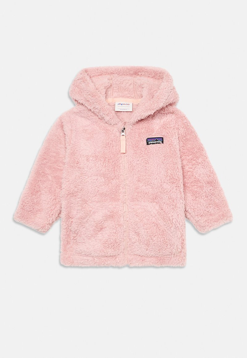 Giacca con cappuccio fuzzy rosa, dotata di una zip frontale, due tasche laterali e un patch logo ricamato sul lato sinistro del petto. Texture morbida e pelosa.