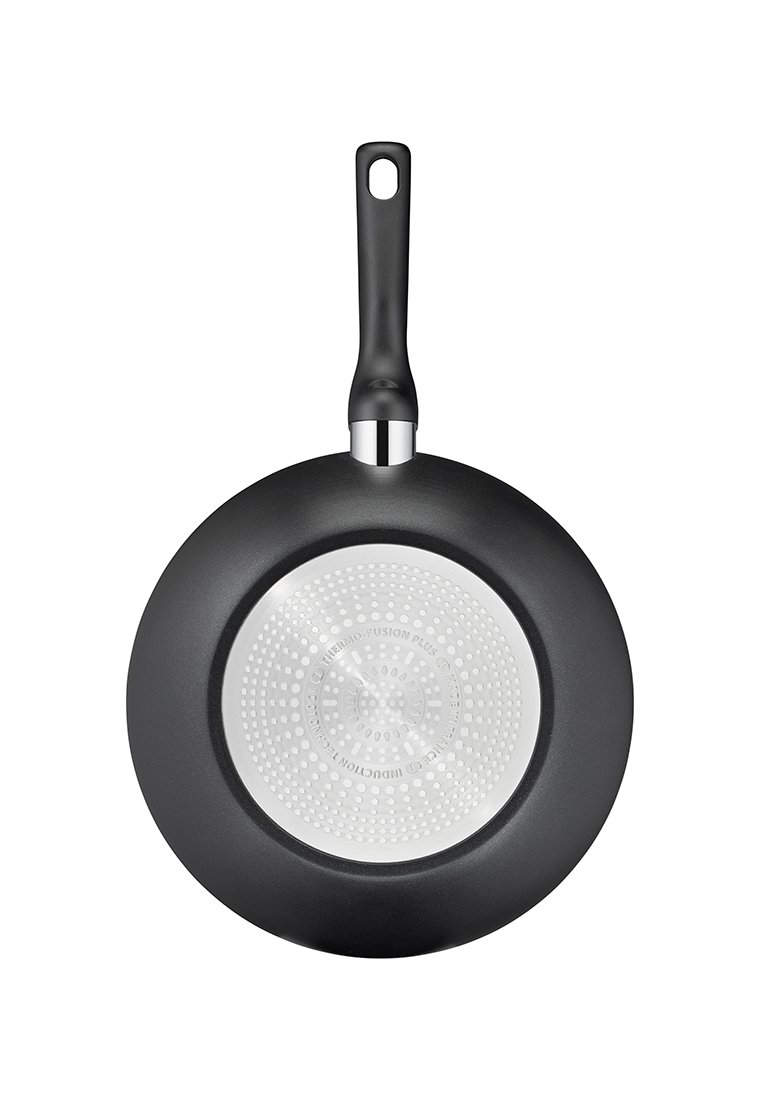 Padella nera con fondo antiaderente e manico nero con un foro per appenderla, vista dal fondo.