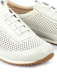 Sneaker in pelle bianca perforata con finitura testurizzata, caratterizzate da un design con lacci e suola in gomma per una migliore aderenza.