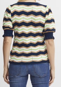 Pletený svetr s chevronovým vzorem v námořnické modři, hnědé, zelené a bílé. Hladké manžety a lem, krátké nabrané rukávy, jemná textura.