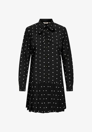 Crna haljina-košulja s bijelim točkicama, dugim rukavima, ovratnikom s mašnom, prednjim gumbima i detaljem naborane suknje. Tkanina od pamučne mješavine.