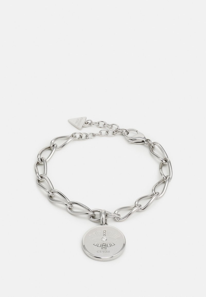 Bracelet chaîne en argent avec des maillons en forme de cœur et un pendentif rond gravé d'un motif rayons de soleil et petits cristaux, de la marque Guess.