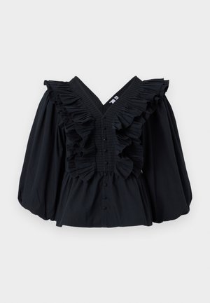 Svart topp med V-ringning, volangdetaljer längs halsringningen och puffärmar. Har en knappstängning framtill. Slät tygtextur.