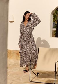 Leopardprint lange mouwen wikkeljurk met een strik taille, gemaakt van lichtgewicht stof, met een diepe V-hals en een vloeiende rok.