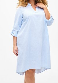 Hellblau gestreiftes Kleid mit Kragen, hochgerollten langen Ärmeln, lässiger Passform und einem asymmetrischen Saumdesign. Weiche Textur, lässiger Stil.