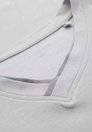 Light gray t-shirt with a textured fabric, featuring a V-neck design and a subtle mesh trim along the neckline.