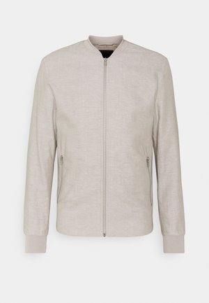 Light beige bomber jacket made from woven fabric, featuring a zip closure, side pockets, ribbed cuffs, and a round neckline.