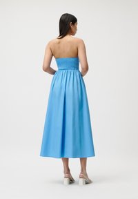 Mėlynas, be petnešėlių maxi suknelė su surištu bodice ir plačia sijonu. Lygus, lengvas audinys iki puskojų.