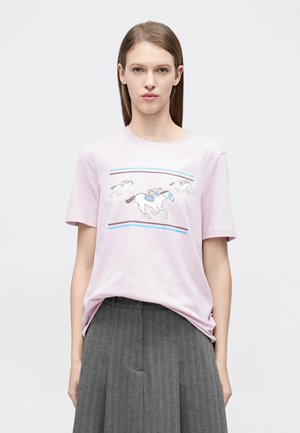 Light pink cotton t-shirt featuring a print of galloping horses with riders, accented by blue and brown stripes. Short sleeves and relaxed fit.