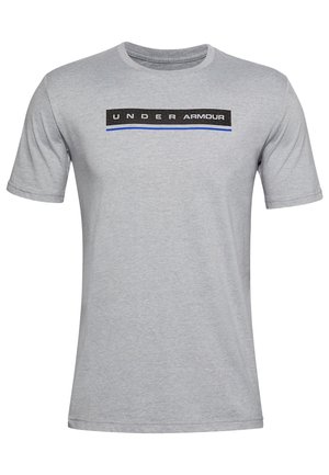 Jasnoszara koszulka z krótkim rękawem z czarnym prostokątnym logo i niebieską linią poniżej, z tekstem "UNDER ARMOUR" na wysokości klatki piersiowej.
