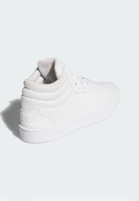 Biele vysoké tenisky s textúrovaným plátnom a hladkými syntetickými doplnkami. Obsahujú perforované detaily a gumovú podrážku.