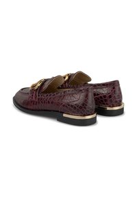 Mocassins en faux-croco marron avec des accents en métal doré, semelle plate noire et surface texturée. Design léger et forme classique.