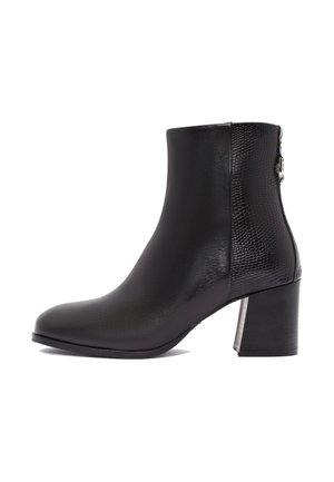Bottines noires à finition en cuir lisse et panneau latéral texturé. Elles présentent un talon épais et des accents métalliques. Surface lisse.
