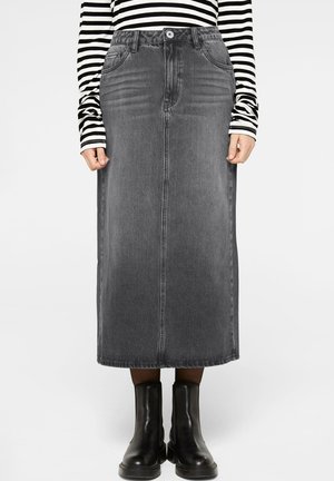 Denim maxi skirt in dark gray, featuring front pockets, a straight cut, and belt loops. Paired with black ankle boots and a striped top.