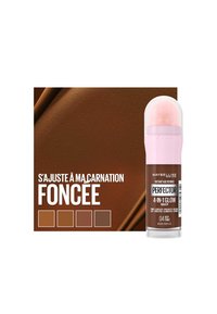 Maybelline Perfecter 4-en-1 Glow Makeup dans un tube transparent avec un applicateur rose. Teinte marron riche avec un fond lisse et métallique ainsi que des échantillons.