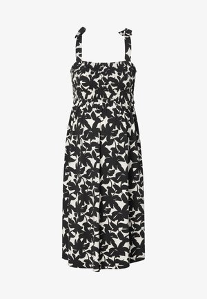 Zwart-witte bloemenjurk met een smock-borstvoorkant, verstelbare schouderbanden en een vloeiende rok. Gemaakt van lichtgewicht stof.