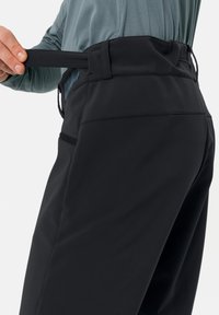 Svarta mjuka skalbyxor med platt midja och justerbar rem, med sidofickor och en slät yta.