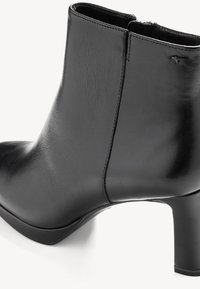 Bottine noire en cuir lisse avec bout arrondi, petit talon bloc et fermeture éclair latérale discrète.