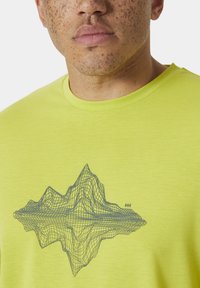 Camiseta verde lima con un diseño de montaña en alambre negro. Textura suave con un escote clásico de cuello redondo.