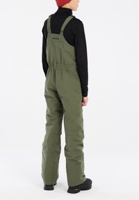 Salopette verde con spalline regolabili, vita elastica e una texture liscia. Presenta un logo sul retro e tasche sui lati.