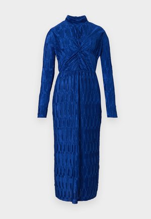 Modré šaty s dlhým rukávom a vysokým golierom. Textúrovaná látka obsahuje vertikálne pruhy a záhyby, sťahujúce v oblasti pása, s dĺžkou až po polovicu lýtok.