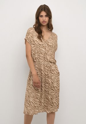 Vestido color arena con escote en V, mangas cortas y cintura ajustada. La tela tiene un patrón de rayas de cebra en marrón oscuro.