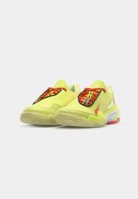 Neon yellow athletic shoes with red and black laces, textured upper, and a rugged sole, featuring a distinctive design and accents.