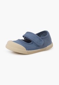 Zapato de lona azul con punta redonda y suela de goma beige. Cuenta con una correa de Velcro para el cierre y detalles de tejido texturizado.