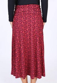 Blumiger Maxirock in verschiedenen Rosa- und Rottönen mit tailliertem Bund und fließendem Saum. Das Muster zeigt kleine Blumen auf einem dunklen Hintergrund.