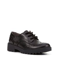 Scarpe in pelle nera con dettagli brogue, allacciate e con suole in gomma spesse. Il design presenta una finitura liscia e accenti di pattern testurizzati.