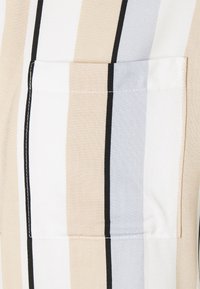 Camicia a maniche corte a righe con righe verticali beige, bianche, nere e azzurro chiaro. Include una tasca sul petto con cuciture visibili.